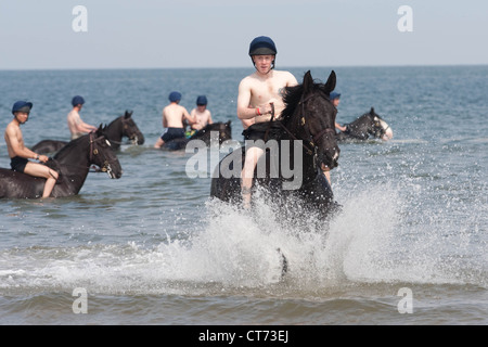 Les membres de la famille royale et de Blues (Household Cavalry) exercer leurs montures sur Holkham Beach à Norfolk Banque D'Images