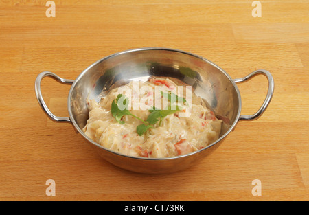 Poulet au curry balti dans un plat sur une surface en bois Banque D'Images