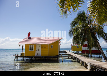 Cabines à bord de l'eau jaune El Faro del Sur hotel Colibri Isla Carenero, l'archipel de Bocas del Toro, PANAMA. Banque D'Images