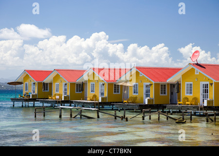 Cabines à bord de l'eau jaune El Faro del Sur hotel Colibri Isla Carenero, l'archipel de Bocas del Toro, PANAMA. Banque D'Images