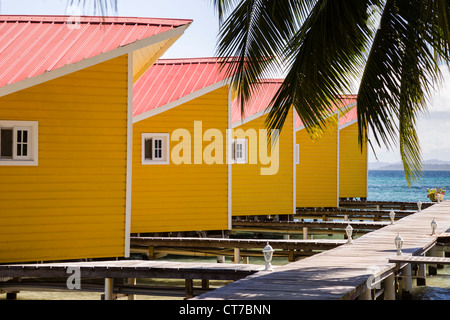 Cabines à bord de l'eau jaune El Faro del Sur hotel Colibri Isla Carenero, l'archipel de Bocas del Toro, PANAMA. Banque D'Images