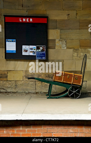 Bagages sur vieux chariot vintage sur la plate-forme Pickering Railway train Station NYMR North Yorkshire Angleterre Royaume-Uni GB Grande-Bretagne Banque D'Images