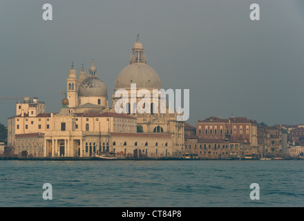 La Punta della Dogana et l'église de Santa Maria della Salute à l'embouchure du Grand Canal, Venise, Italie, vu dans un lever de soleil brumeux Banque D'Images