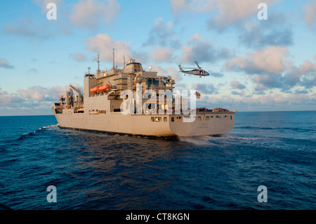 Un hélicoptère Seahawk SH-60 de la Marine américaine ramasse des palettes de fournitures du navire de cargaison sèche et de munitions USNS Amelia Earheart (T-AKE 6) lors d'un réapprovisionnement en mer avec le destroyer de missile guidé USS McCampbell (DDG 85), non représenté, en mer de Chine orientale le 8 juillet 2012. McCampbell était en cours de réalisation d'opérations de sécurité maritime et de coopération en matière de sécurité théâtrale dans la 7e flotte américaine. Banque D'Images