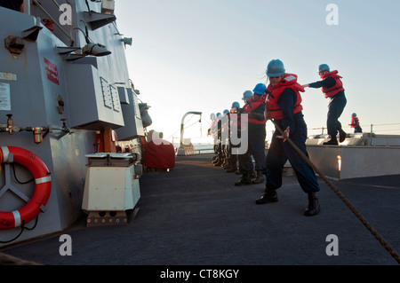 Les marins américains affectés au destroyer à missiles guidés USS McCampbell (DDG 85) ont héli en ligne pendant une reconstitution en mer dans la mer de Chine orientale le 8 juillet 2012. McCampbell était en cours de réalisation d'opérations de sécurité maritime et de coopération en matière de sécurité théâtrale dans la 7e flotte américaine. Banque D'Images