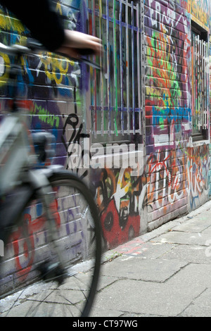 Cycliste le long Werregaren Straat - rue de Gand où les graffitis sont Bruxelles Gand juridique Banque D'Images