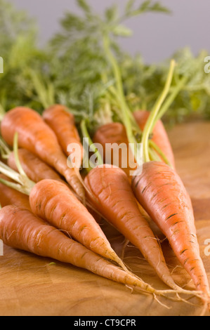 Tout organique des carottes sur une planche en bois Banque D'Images