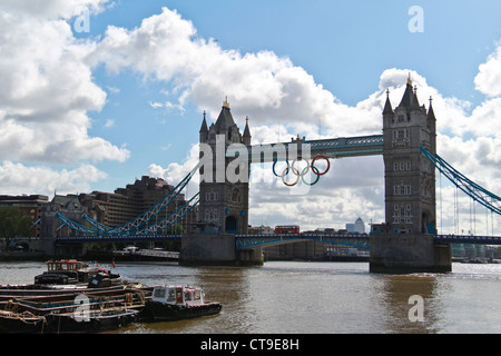 Vue sur le Tower Bridge avec anneau olympique symbole sur l'affichage, bateaux et bâtiments de bureaux à Londres. Red bus traversant le pont Banque D'Images