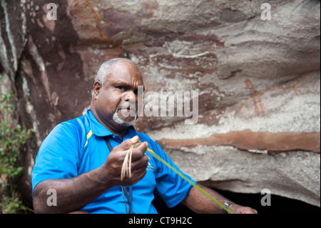 Nugal-warra elder Wilfred Willie Gordon d'Guurrbi tours explique l'art rupestre aborigène peinture rupestre sur les terres autochtones, Cooktown Banque D'Images