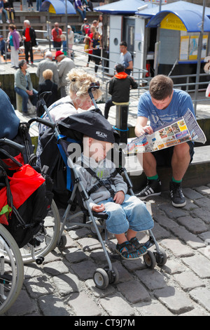 Jeune garçon prendre une sieste dans sa poussette sur les quais de Nyhavn tandis que ses parents sont contrôle de la carte de la ville de Copenhague, dans l'ambiance agréable Banque D'Images