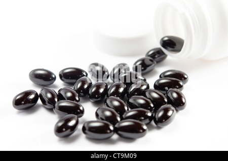 Close-up pills spilling out de bouteille de pilules sur fond blanc Banque D'Images