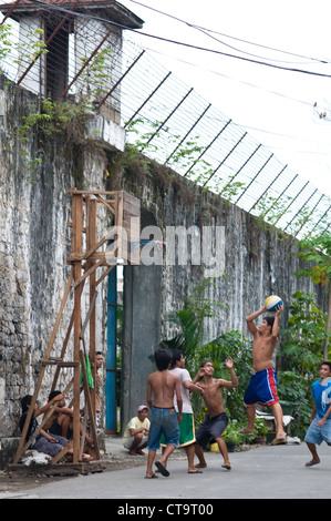 Garçons jouant au basket-ball à l'extérieur de la prison provinciale de Cebu, Cebu City, Philippines Banque D'Images