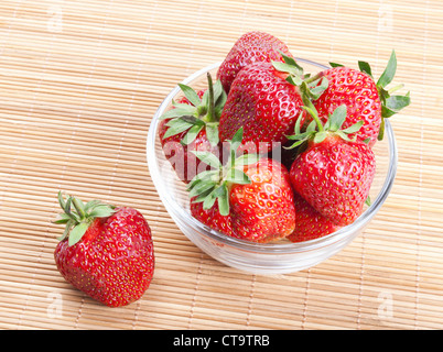 Bol en verre avec des fraises sur le tapis de bambou Banque D'Images