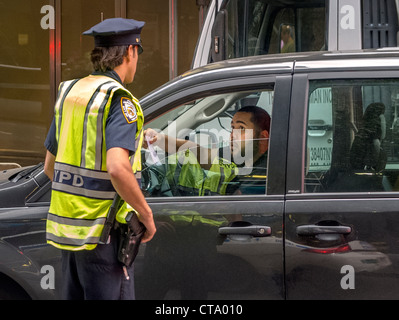 Un chauffeur demande Indications d'un policier à Times Square, New York City. Banque D'Images