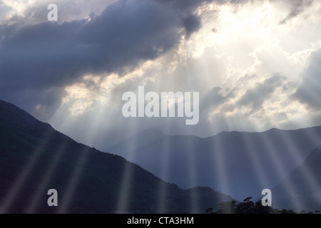 Rayons de soleil perce les nuages Banque D'Images