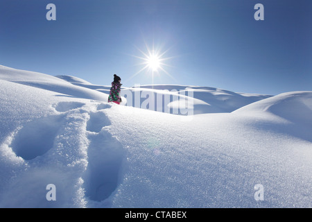 Jeune fille marchant lourdement dans la neige profonde, l'Arlberg, Jufa, Tyrol, Autriche Banque D'Images