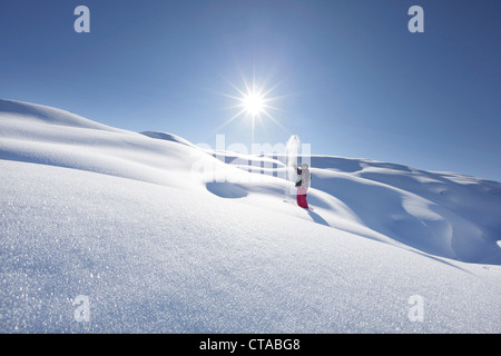 Jeune fille marchant lourdement dans la neige profonde, l'Arlberg, Jufa, Tyrol, Autriche Banque D'Images