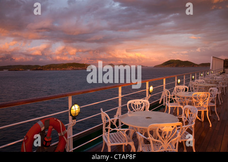 Des tables et des chaises sur le pont du bateau de croisière MS Deutschland, Peter Deilmann Reederei, avec de gros nuages au coucher du soleil, Cabo Frio, Rio de Banque D'Images