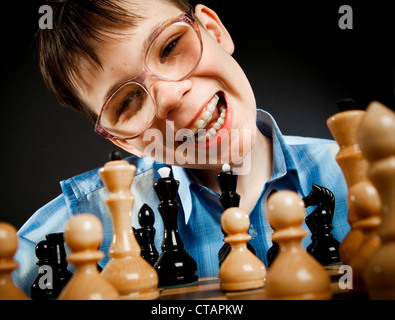 Nerd jouer aux échecs sur un fond noir Banque D'Images
