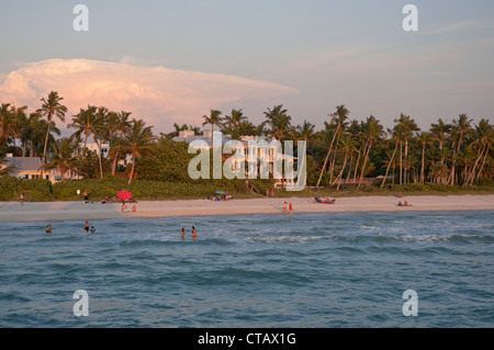 Coucher du soleil la lumière baigne le Naples Florida Plage municipale le long du golfe du Mexique. Banque D'Images