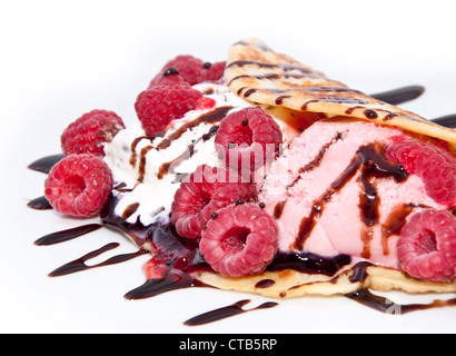 Glace à la framboise fraîche dans une casserole gâteau décoré avec les framboises et le sirop de chocolat Banque D'Images