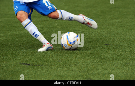 Football mitre qui se fait frapper par un joueur sur une pelouse synthétique 3G hauteur à Maidstone United sol Banque D'Images