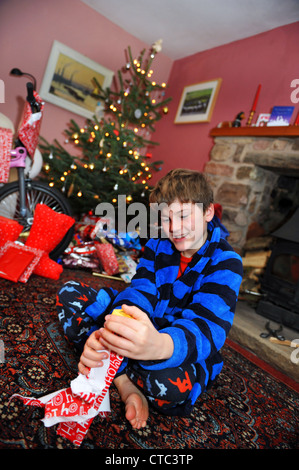 Un garçon de onze ans ouvre son stock le jour de Noël. Banque D'Images