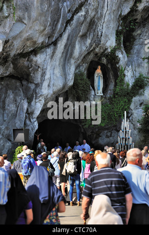 Pèlerins priant devant la grotte au Sanctuaire de Notre-Dame de Lourdes, Pyrénées, France Banque D'Images