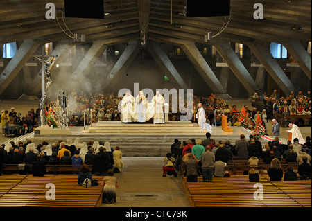 Service religieux à la basilique Saint Pie X / basilique souterraine au Sanctuaire de Notre-Dame de Lourdes, Pyrénées, France Banque D'Images