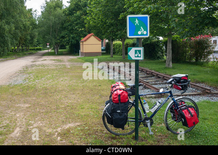 Randonnée vélo appuyé contre un poteau indicateur sur un velo route en Bretagne France Banque D'Images