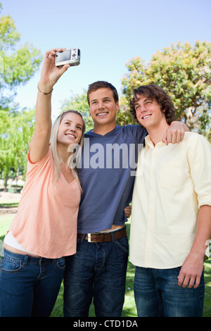 Trois smiling friends de prendre une photos d'eux-mêmes Banque D'Images
