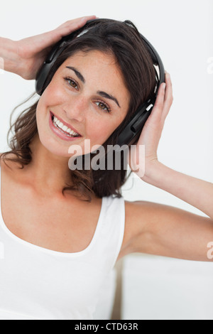 Portrait of a smiling brunette listening to music Banque D'Images