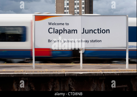 Panneau de Bienvenue sur la plate-forme de Clapham Junction Station, avec le train passé flou en arrière-plan, en Angleterre. Banque D'Images