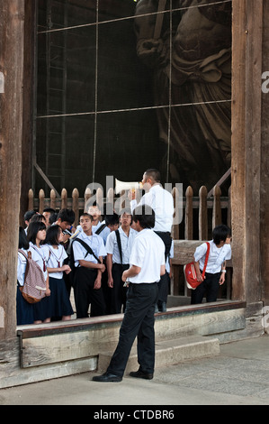 Un groupe scolaire japonais écoute un guide au temple Todai-ji, Nara, Japon Banque D'Images