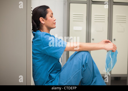 Penser doctor sitting in a locker room Banque D'Images