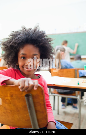 Smiling schoolgirl tourné autour pendant la classe Banque D'Images