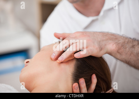 Médecin la manipulation du côté de la tête de son patient Banque D'Images