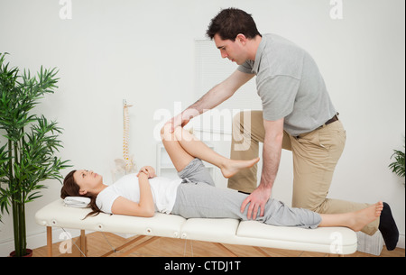 Femme étant l'examen de sa jambe par un chiropraticien Banque D'Images
