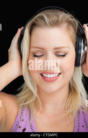 Femme blonde joyeuse portant son casque Banque D'Images