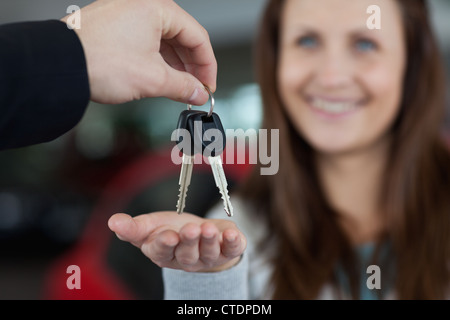 Woman smiling lors de la réception des clés de voiture Banque D'Images