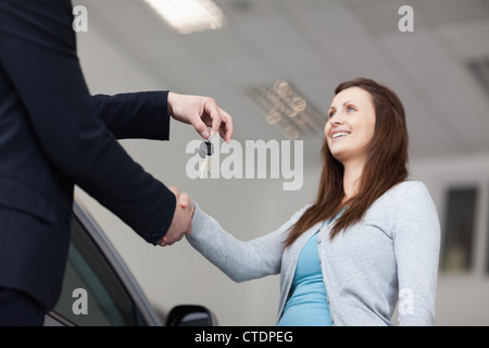 Client recevant des clés de voiture et en agitant la main Banque D'Images