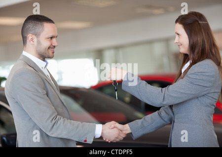 L'homme de recevoir des clés de voiture et en agitant la main Banque D'Images