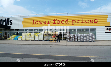 Pas de chichis à l'extérieur du supermarché, affiche « bas prix des aliments » et un acheteur poussant le chariot en Ontario, Canada, Amérique du Nord KATHY DEWITT Banque D'Images