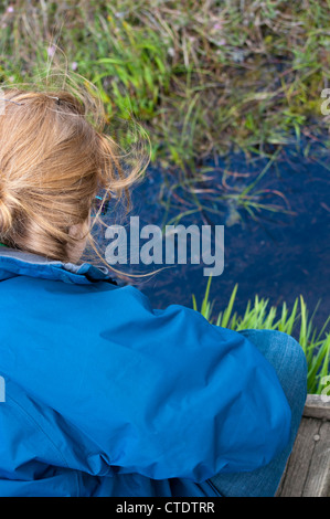 Fille à la zone humide en étang sur sentier nature réserve naturelle de la tourbière de Dersingham Banque D'Images