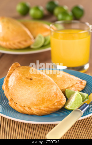 Snack-péruvien appelé Empanada (PIE) rempli de poulet et de boeuf servi avec limes Banque D'Images