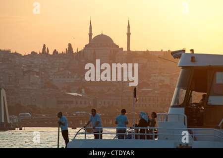 ISTANBUL, TURQUIE. Un traversier sur la Corne d'or au coucher du soleil, avec la mosquée de Yavuz Selim derrière. 2012. Banque D'Images