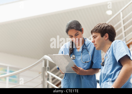 Nurse holding a presse-papiers tout en regardant il Banque D'Images