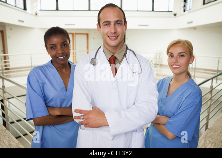 Smiling doctor and nurses looking at camera Banque D'Images