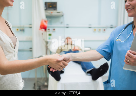 Nurse shaking part d'un patient Banque D'Images