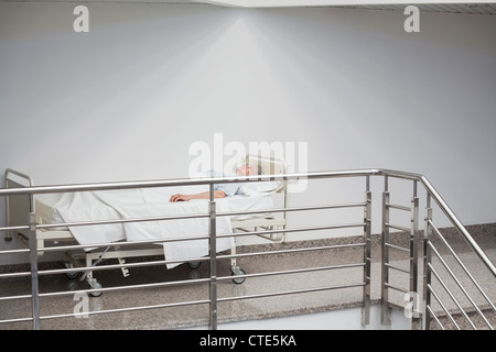 Patient âgé de dormir dans le couloir Banque D'Images